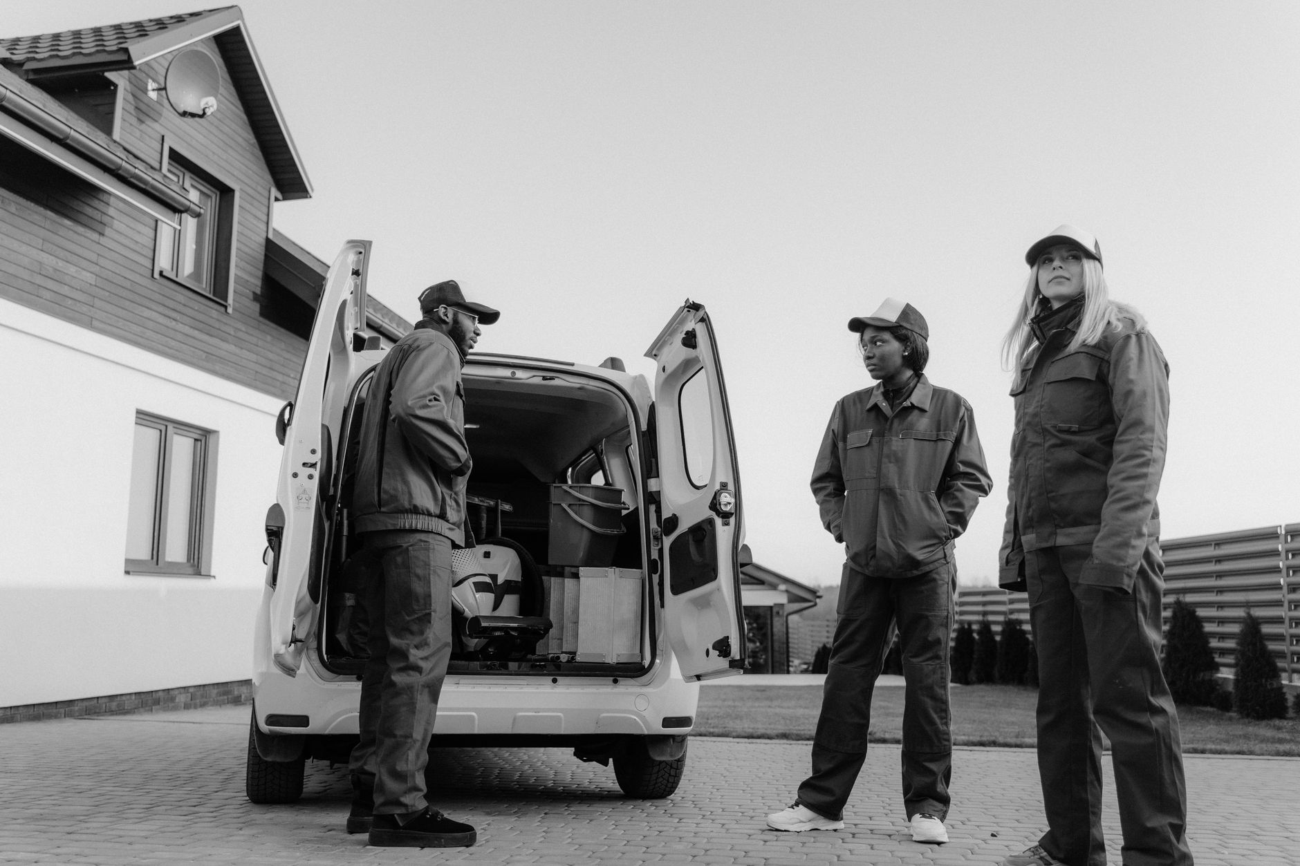 Drie monteurs bij de bestelwagen voor een woning